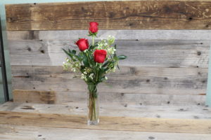 3 red roses in a vase.