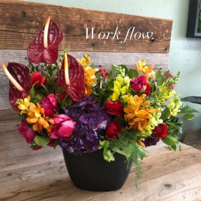 Colorful custom flower arrangement sitting on a table.