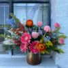 Colorful custom flower arrangement sitting on a window ledge.