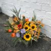 Colorful custom flower arrangement sitting on the ground.