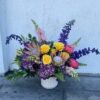 Colorful custom flower arrangement sitting on the floor.