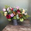 Colorful custom flower arrangement sitting on a table.