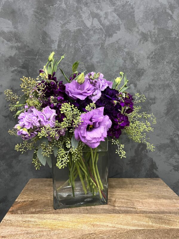 Purple flower arrangement in a glass vase.