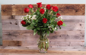 Dozen red roses in glass vase.