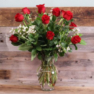 Dozen red roses in glass vase.