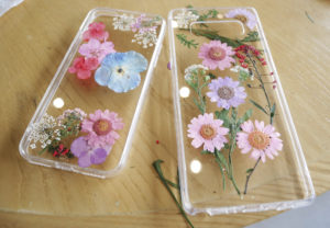 Photo of pressed flowers in a phone case as a creative use for dried flowers.