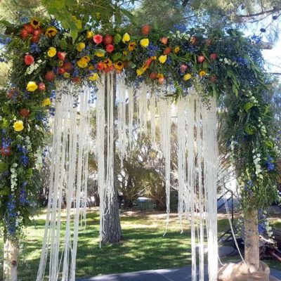 Wedding arbor of greenery and flowers.