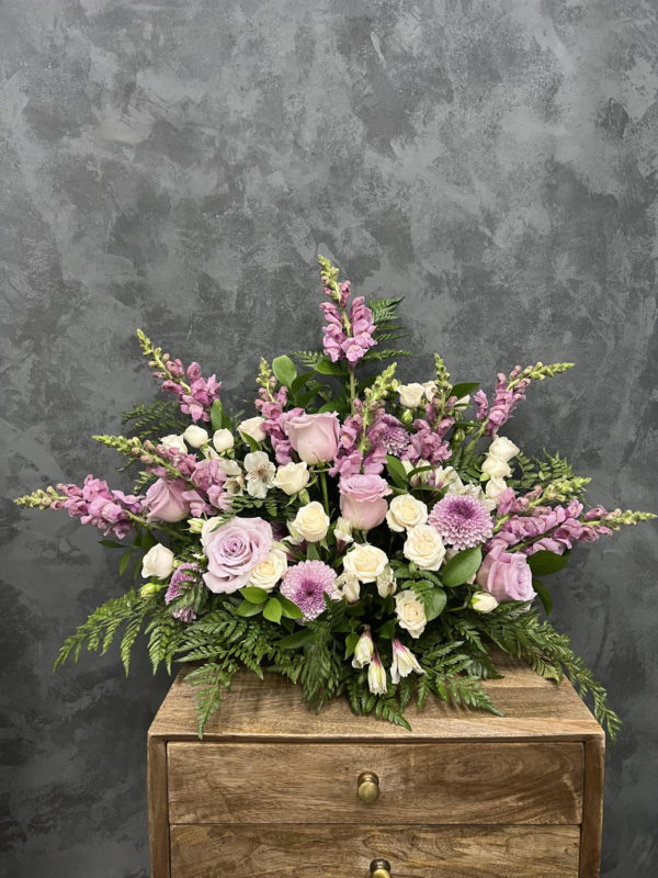 Large flower arrangement with mixture of purple flowers.