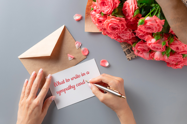 Женщина пишет открытку на сером столе с букетом розовых роз.