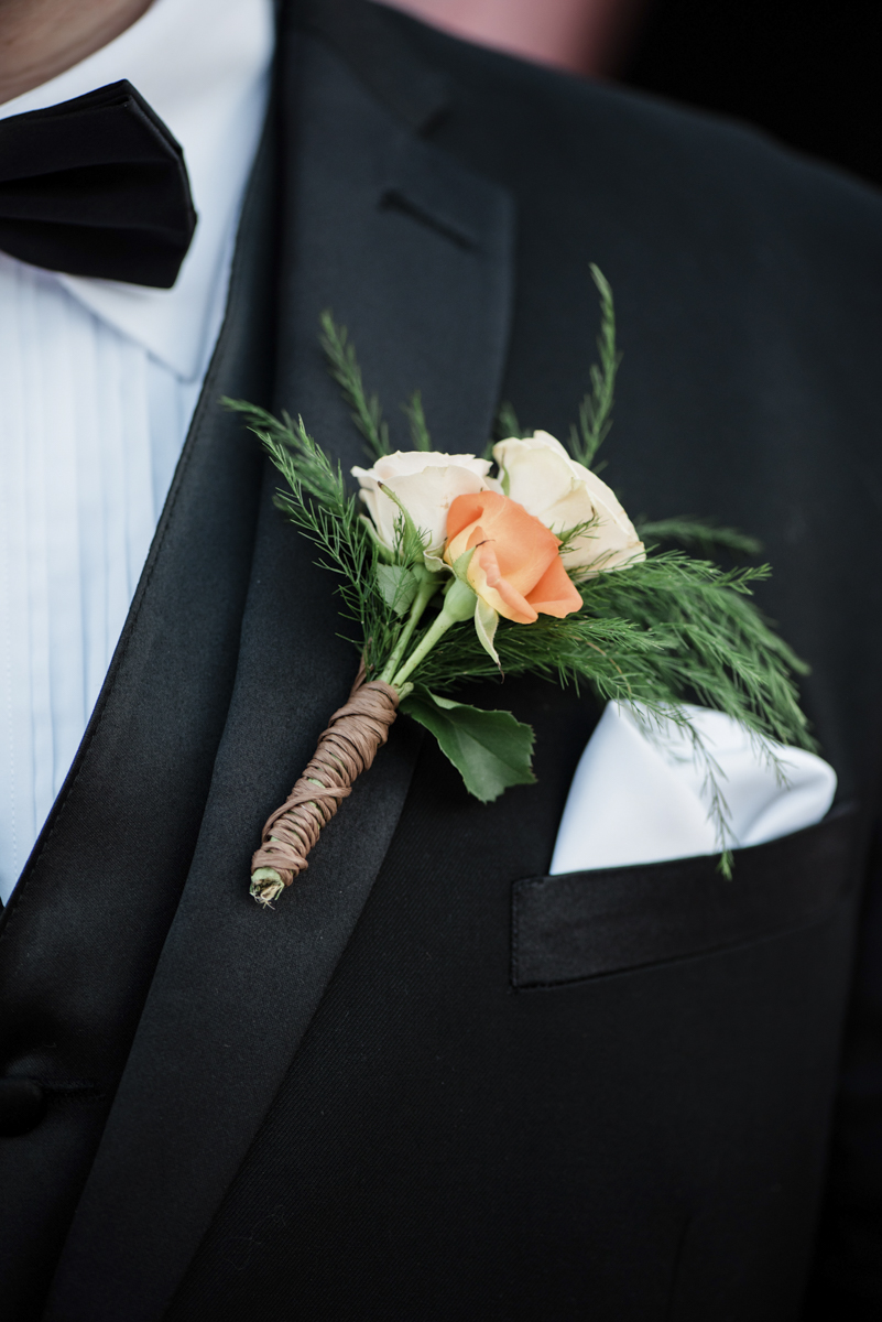 Peach and white flowers for groom boutonnière