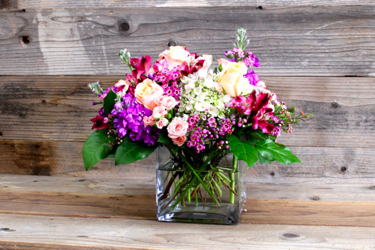 Purple and white cut flower arrangement in a vase.