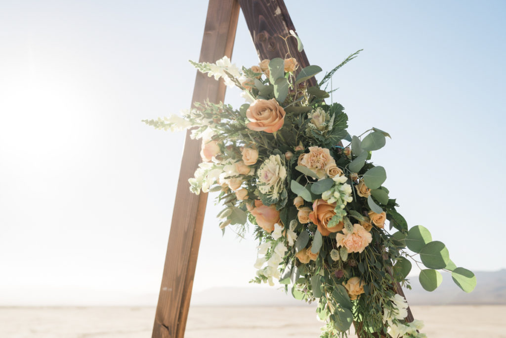 Wedding florals on a wooden arch.