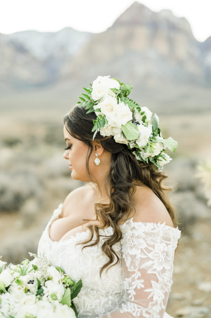 Bride with wedding headpiece made of white flowers and greenery.