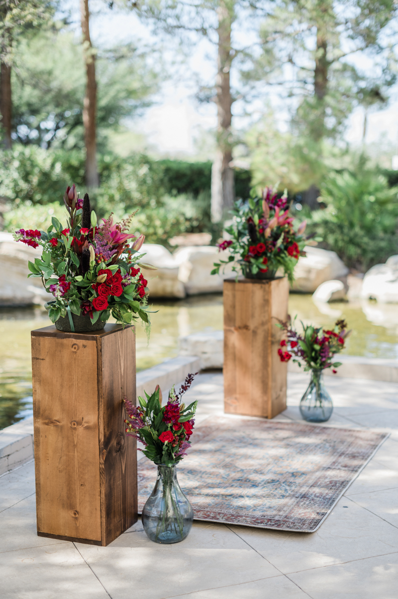 Ceremony florals on wooden pedestals.