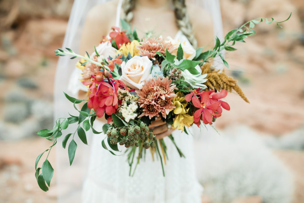Wedding Florist Las Vegas Bride holding garden wedding bouquet of fall colored flowers.