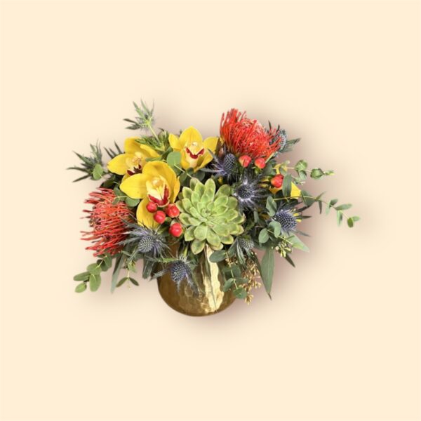 small flower arrangement of orchids and succulents in a gold vase
