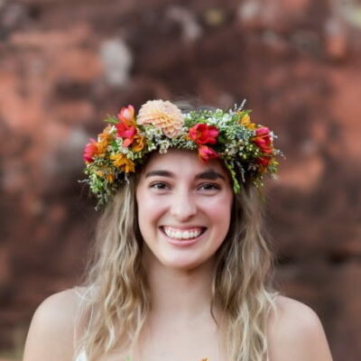 Woman smiling wearing a flower crown on her head.