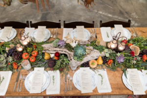 Succulents and flowers decorating a party table setting.