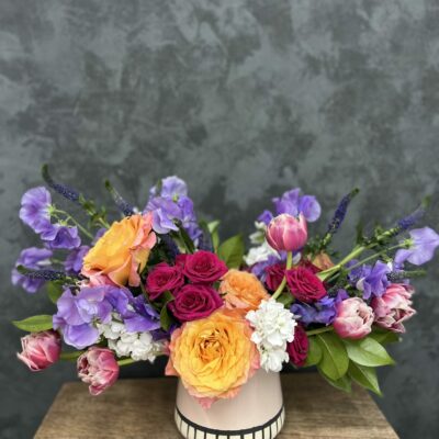 Colorful Valentine's flower arrangement in white ceramic vase.
