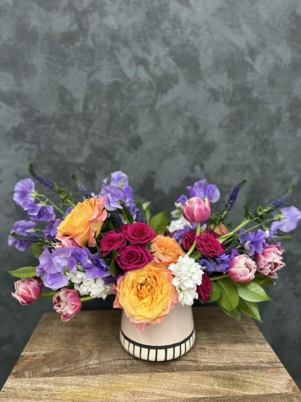 Colorful Valentine's flower arrangement in white ceramic vase.