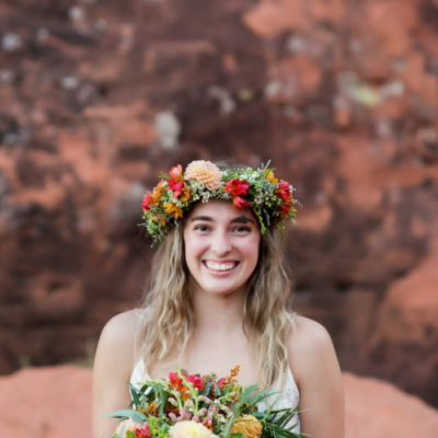 Bridesmaid wearing a red and peach flower crown.