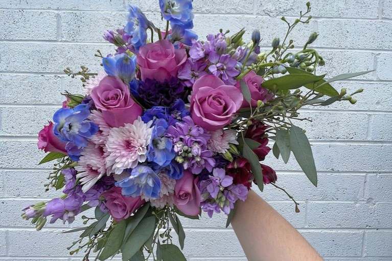 Anniversary bouquet of flowers in purples, blues and pinks.