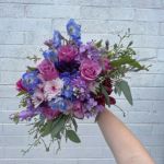 Bride's wedding bouquet made of pink and purple flowers.