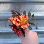 Groom's boutonniere of orange flowers.