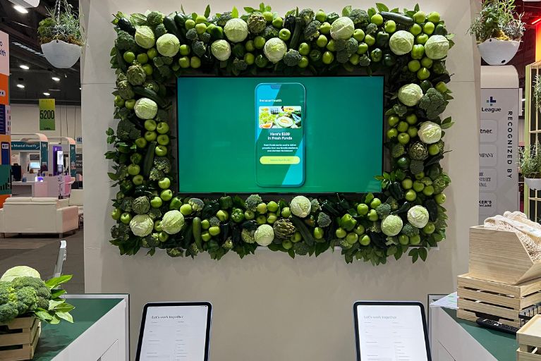 monitor with green display surrounded by a frame of vegetables and greenery.