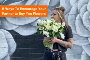 text "6 ways to encourage your partner to buy you flowers" with a photo of a young woman holding a bouquet of white flowers