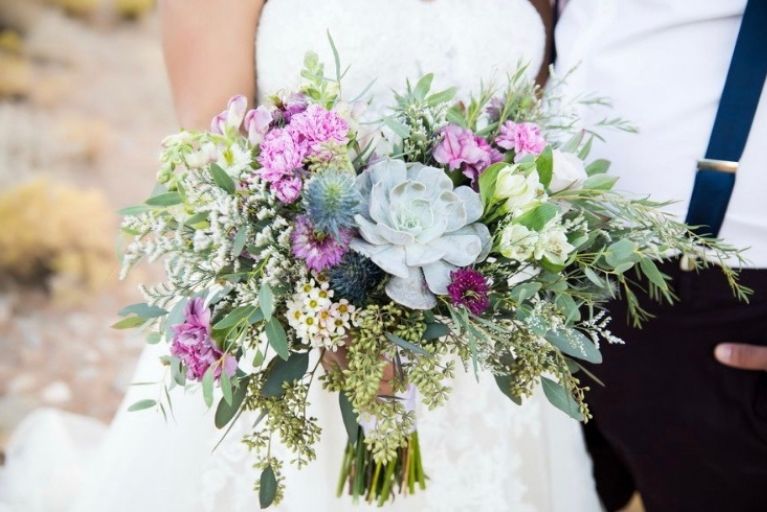 photo of a wedding bouquet held by a bride in a wedding gown
