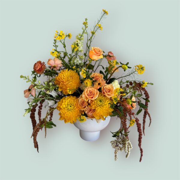 large flower arrangement with spring flowers in a white vase