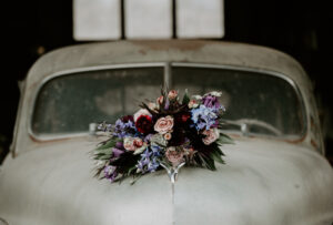 wedding-florist-2 large wedding bouquet of pinks and purples sitting on a vintage car