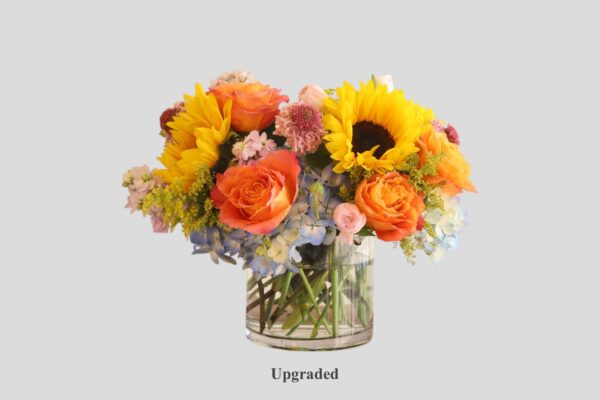 flower arrangement of hydrangea, sunflowers, roses and in a round glass vase