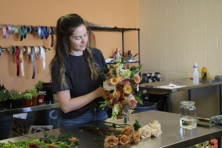 florist arranging a bouquet of flowers in their shop