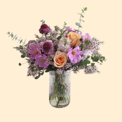 flowers with soft lavender and warm peach tones in a glass vase