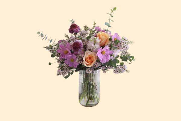 flowers with soft lavender and warm peach tones in a glass vase